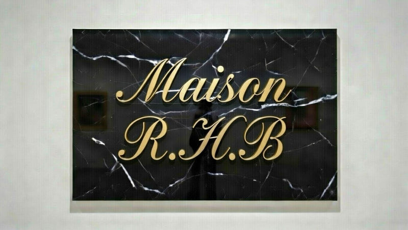 Elegant gold script text on black marble wall art with luxury gallery design
